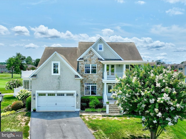 view of front of home featuring a garage, a front lawn, and a balcony