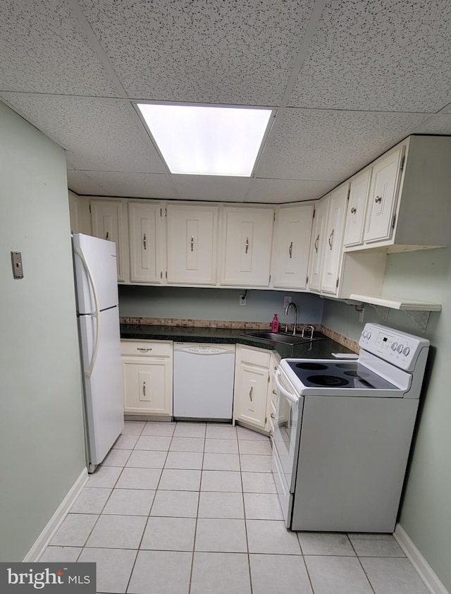 kitchen with light tile patterned floors, white appliances, a drop ceiling, and white cabinets