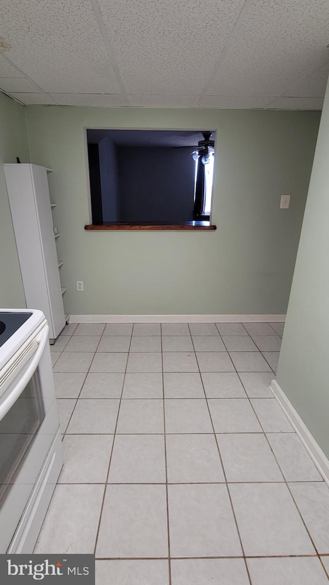 interior space with light tile patterned flooring and a drop ceiling