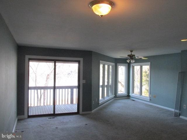 carpeted empty room with ceiling fan and a healthy amount of sunlight