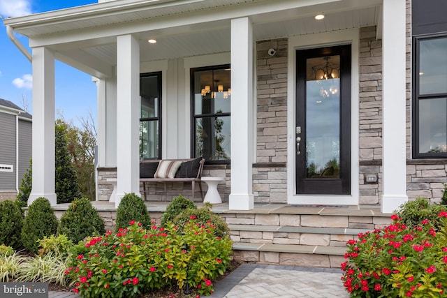 view of exterior entry featuring covered porch