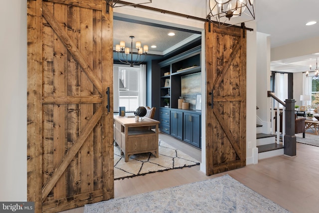 interior space with built in features, crown molding, a chandelier, and hardwood / wood-style flooring