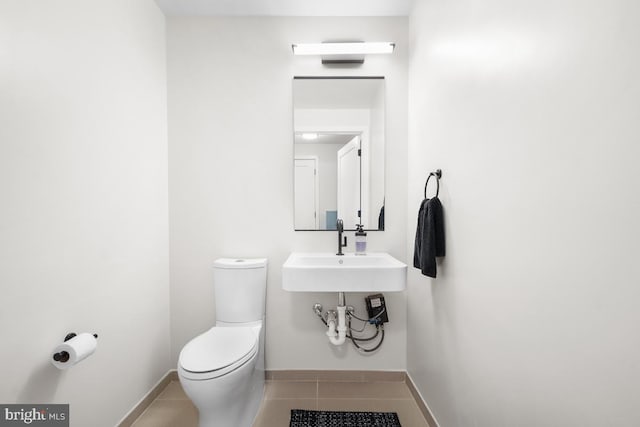 bathroom with tile patterned flooring, sink, and toilet