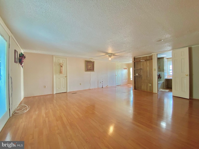 empty room with ceiling fan, hardwood / wood-style floors, and a textured ceiling