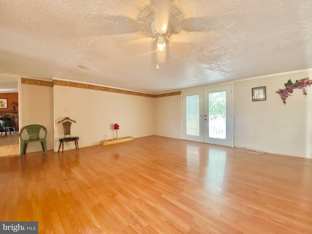 empty room with wood-type flooring, ceiling fan, a textured ceiling, and french doors