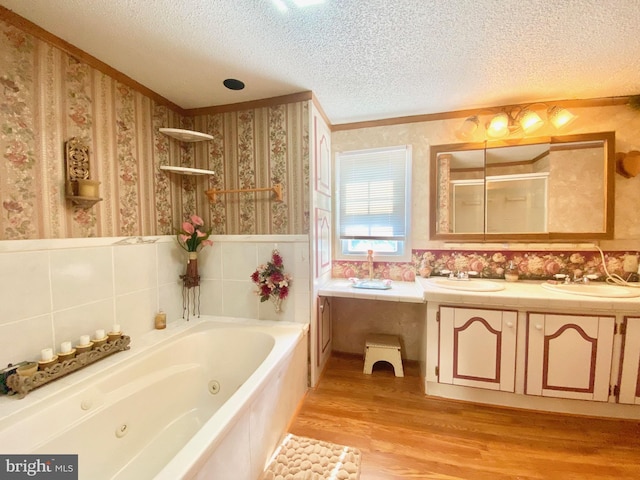 bathroom with vanity, hardwood / wood-style flooring, independent shower and bath, and a textured ceiling