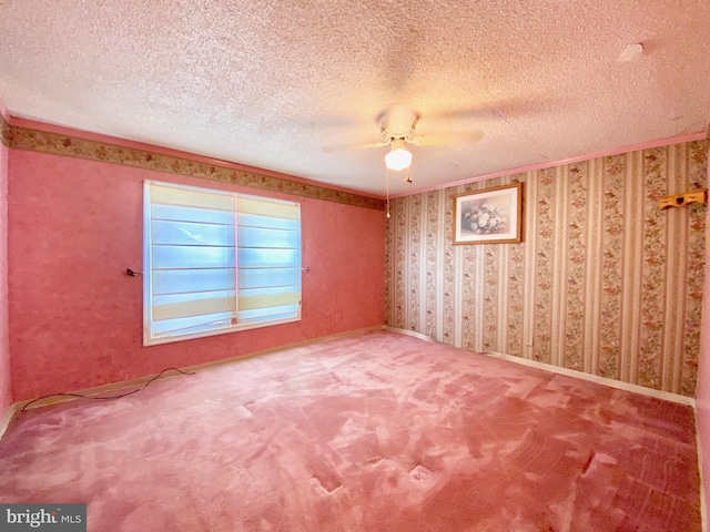 carpeted spare room featuring ceiling fan and a textured ceiling