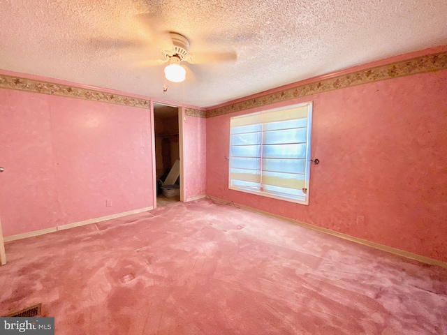 carpeted empty room featuring ceiling fan and a textured ceiling