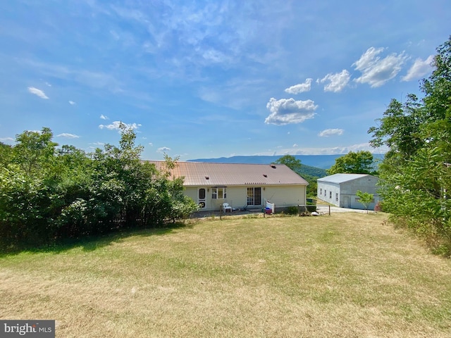 back of house with an outbuilding and a lawn