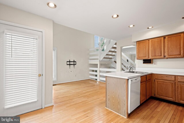 kitchen featuring light hardwood / wood-style floors, sink, kitchen peninsula, and white dishwasher