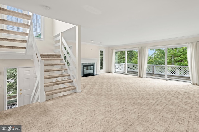 unfurnished living room featuring crown molding, a healthy amount of sunlight, and light colored carpet