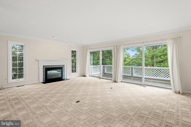 unfurnished living room with crown molding, a fireplace, and light colored carpet