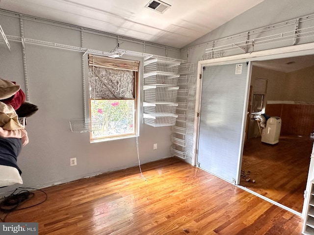 unfurnished bedroom with lofted ceiling, wood-type flooring, and a closet