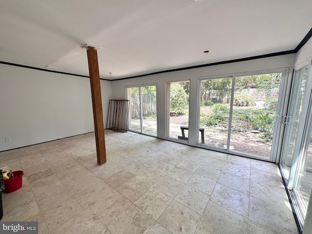 unfurnished room with crown molding and decorative columns