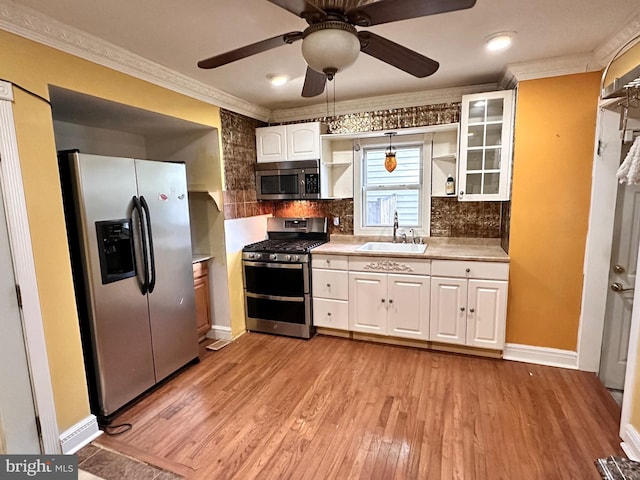 kitchen featuring sink, white cabinetry, decorative light fixtures, light hardwood / wood-style flooring, and stainless steel appliances