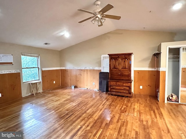 unfurnished living room with hardwood / wood-style flooring, ceiling fan, and lofted ceiling