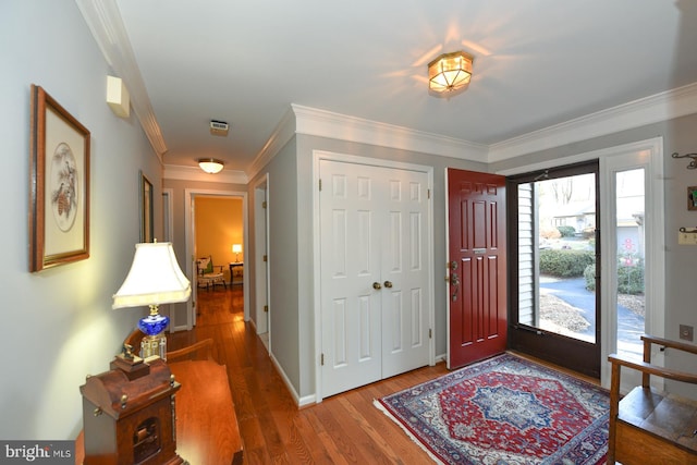 foyer entrance with crown molding and hardwood / wood-style floors