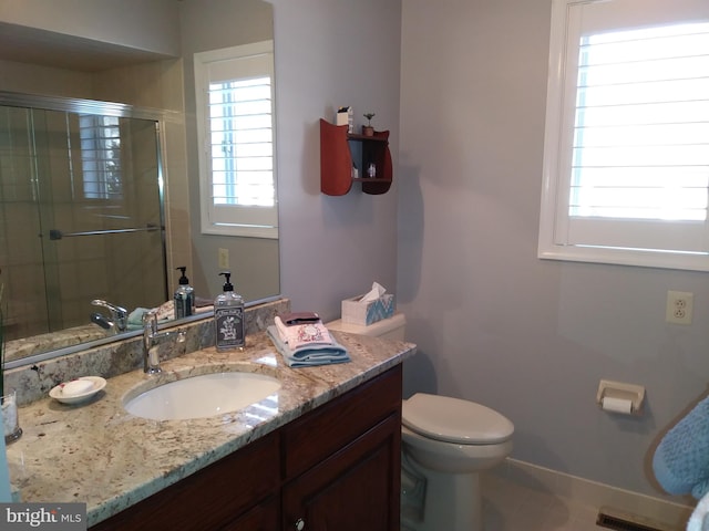 bathroom with vanity, toilet, an enclosed shower, and tile patterned flooring