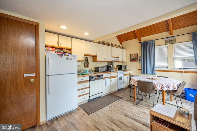 kitchen with cream cabinets, vaulted ceiling with beams, cooling unit, white appliances, and light hardwood / wood-style flooring