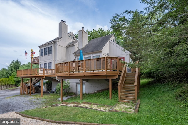 back of house with a deck and a yard