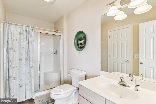 bathroom featuring toilet, a stall shower, and vanity