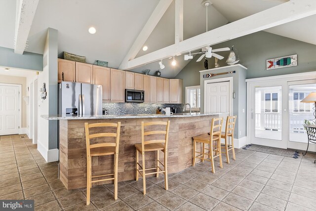 kitchen with high vaulted ceiling, light tile patterned floors, beam ceiling, ceiling fan, and stainless steel appliances