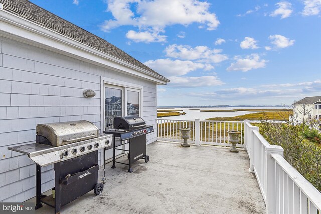 view of patio featuring area for grilling and a water view