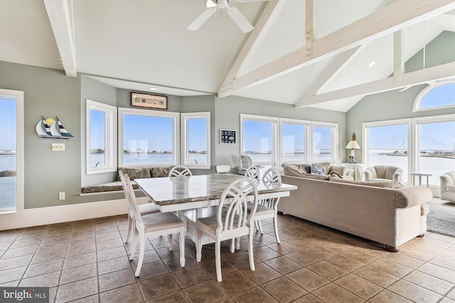 tiled dining space featuring ceiling fan and high vaulted ceiling