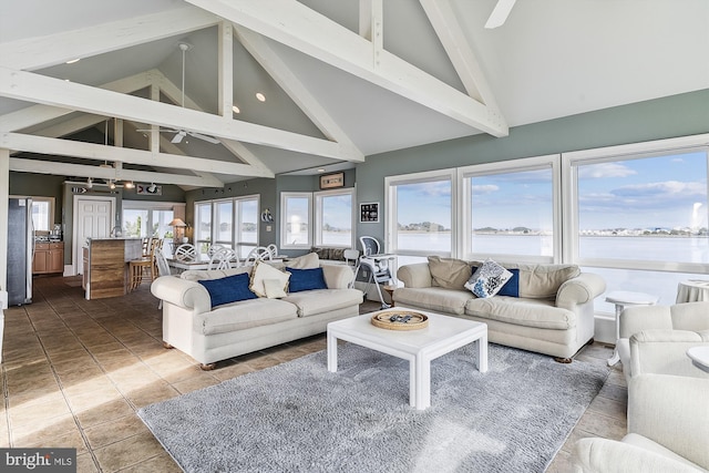 living room featuring beam ceiling, tile patterned floors, high vaulted ceiling, a water view, and ceiling fan