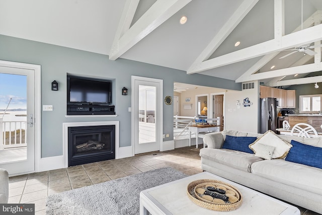 tiled living room with ceiling fan, beam ceiling, and high vaulted ceiling