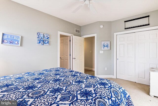 carpeted bedroom with ceiling fan and a closet