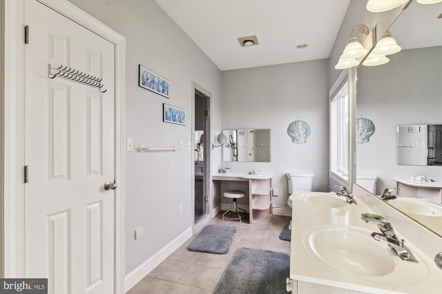 bathroom with toilet, dual bowl vanity, and tile patterned floors