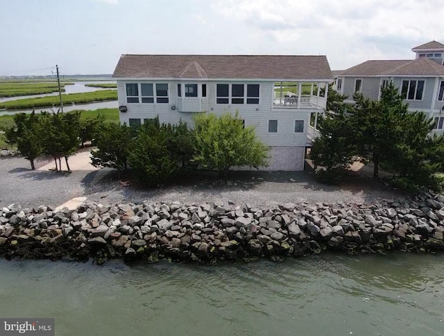 back of property featuring a water view and a balcony