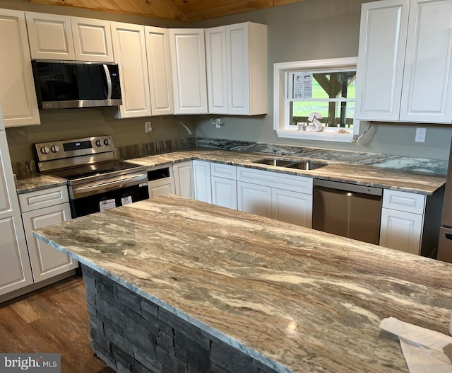 kitchen with white cabinets, stainless steel appliances, dark wood-type flooring, and light stone countertops