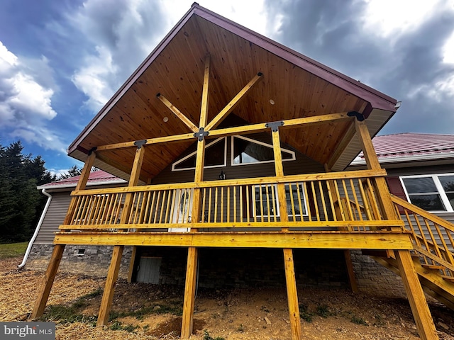 back of house featuring ceiling fan and a wooden deck