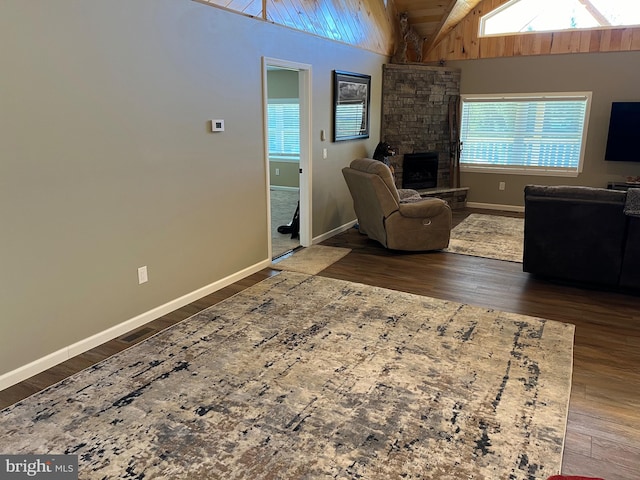 living room featuring vaulted ceiling, a fireplace, dark hardwood / wood-style flooring, and wood ceiling