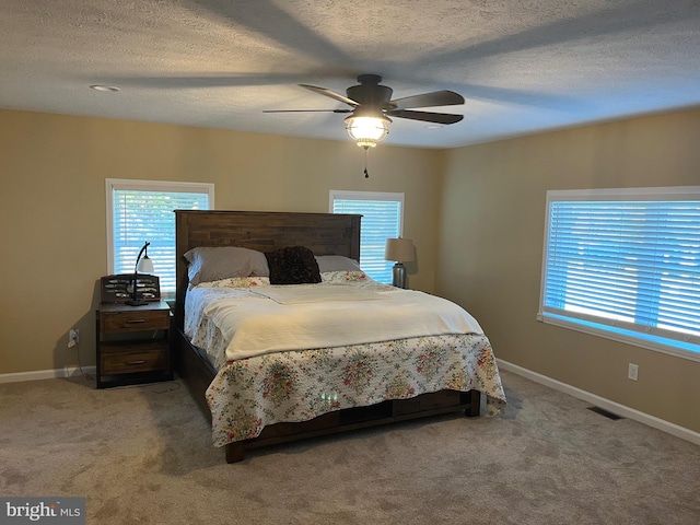 carpeted bedroom featuring a textured ceiling and ceiling fan