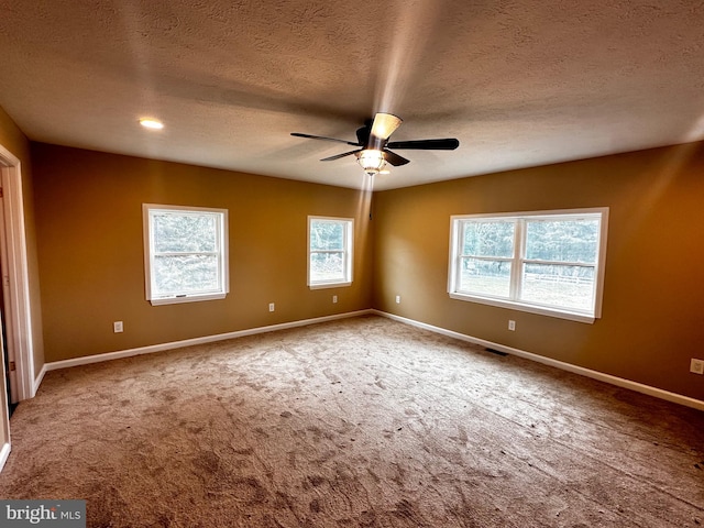 spare room featuring carpet floors, a textured ceiling, and ceiling fan