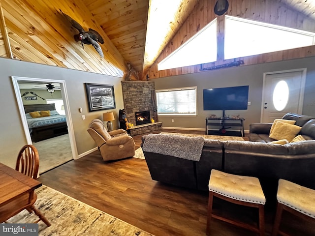 living room with ceiling fan, lofted ceiling, wood-type flooring, wooden ceiling, and a fireplace