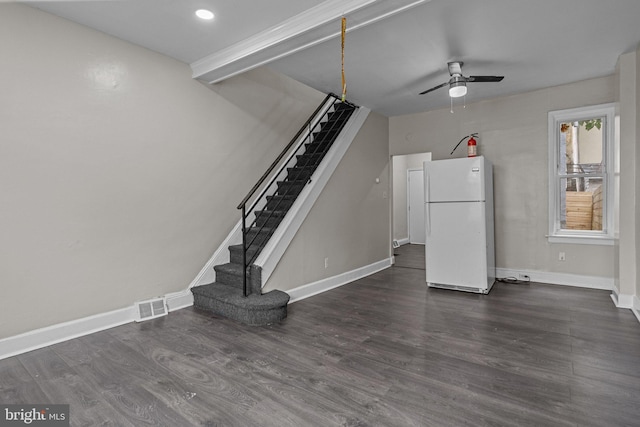 unfurnished living room featuring dark wood-type flooring and ceiling fan