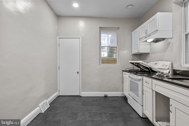 kitchen with white cabinetry, white electric range, sink, and dark stone countertops