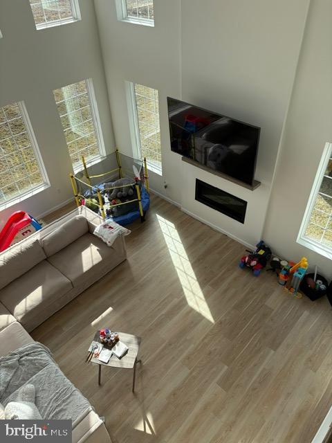 living room with a towering ceiling and wood-type flooring