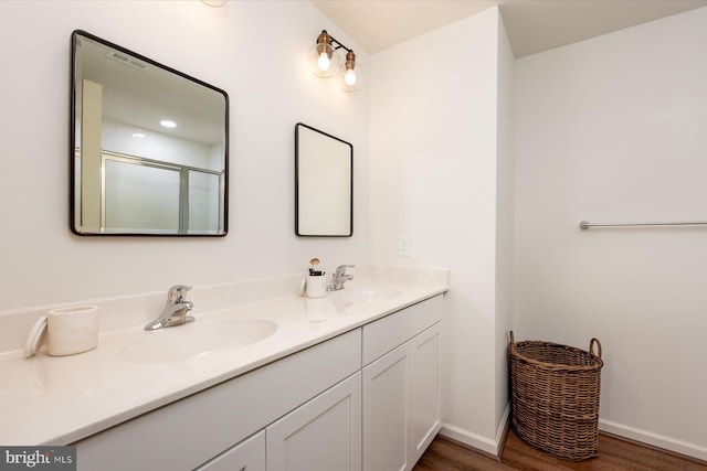 bathroom with vanity, a shower with door, and hardwood / wood-style floors