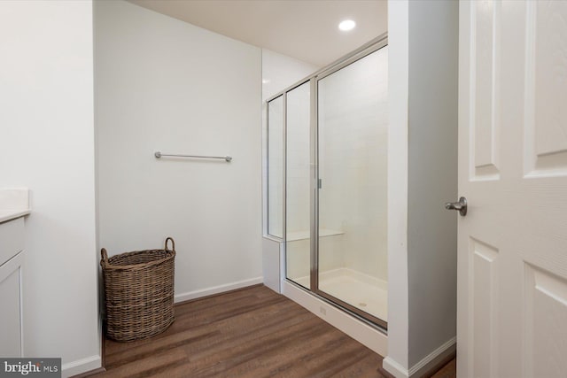 bathroom featuring hardwood / wood-style flooring, vanity, and an enclosed shower