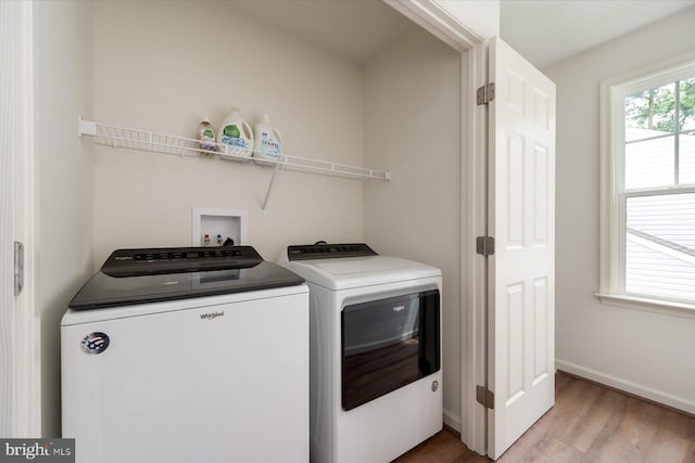 laundry area featuring washer and clothes dryer and light wood-type flooring