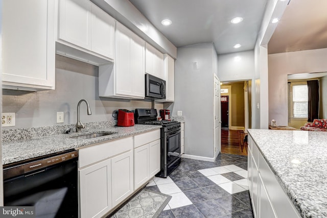 kitchen featuring white cabinetry, sink, black appliances, and light stone countertops