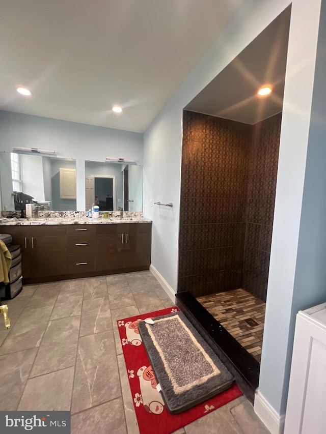 bathroom featuring a shower and vanity