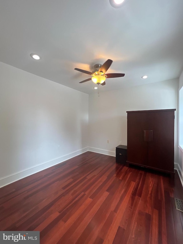 spare room with dark hardwood / wood-style floors and ceiling fan