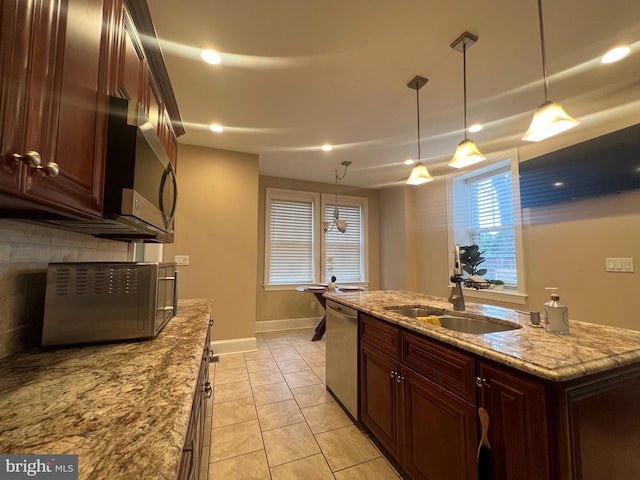 kitchen featuring light stone countertops, pendant lighting, stainless steel appliances, sink, and light tile patterned flooring