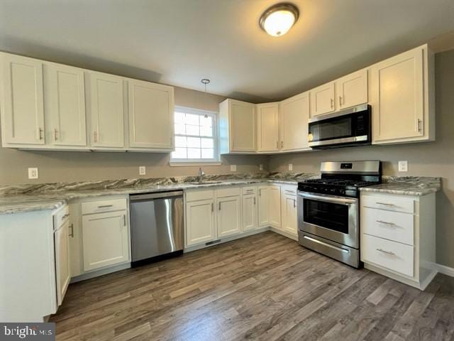 kitchen with white cabinetry, appliances with stainless steel finishes, and dark hardwood / wood-style floors